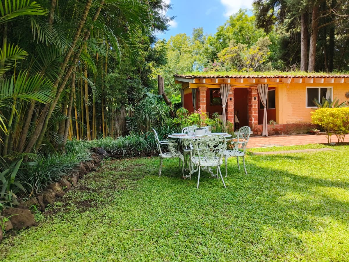 Mesa de hierro blanca en el jardín, frente a la terraza de uno de los bungalows