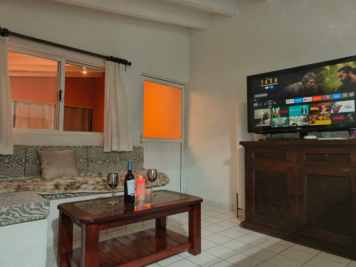 Sala del Bungalow 1 con TV con streaming, mesa de centro y vino