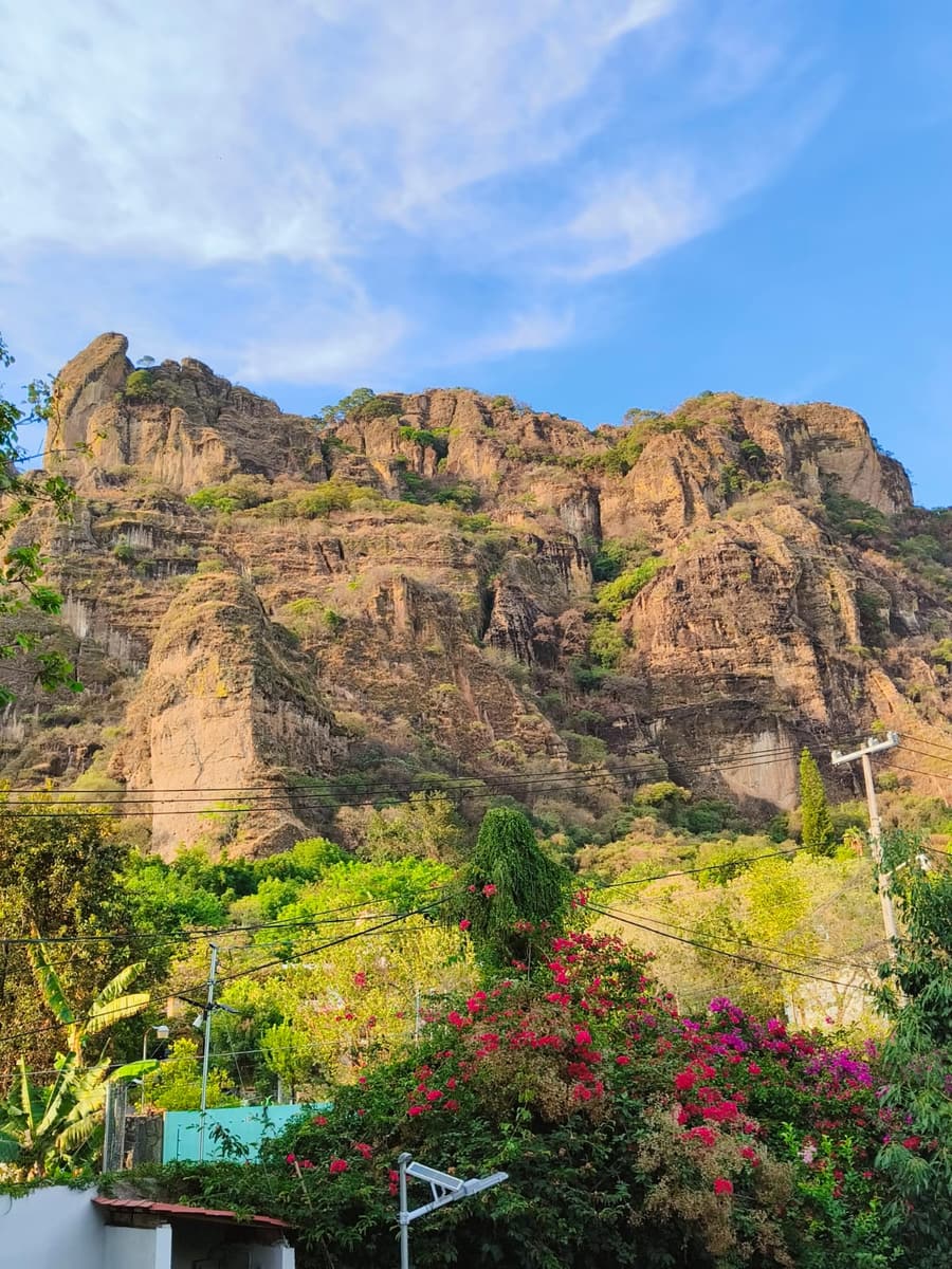 Los cerros de Tepoztlán con bugambilias en flor y cielo azul